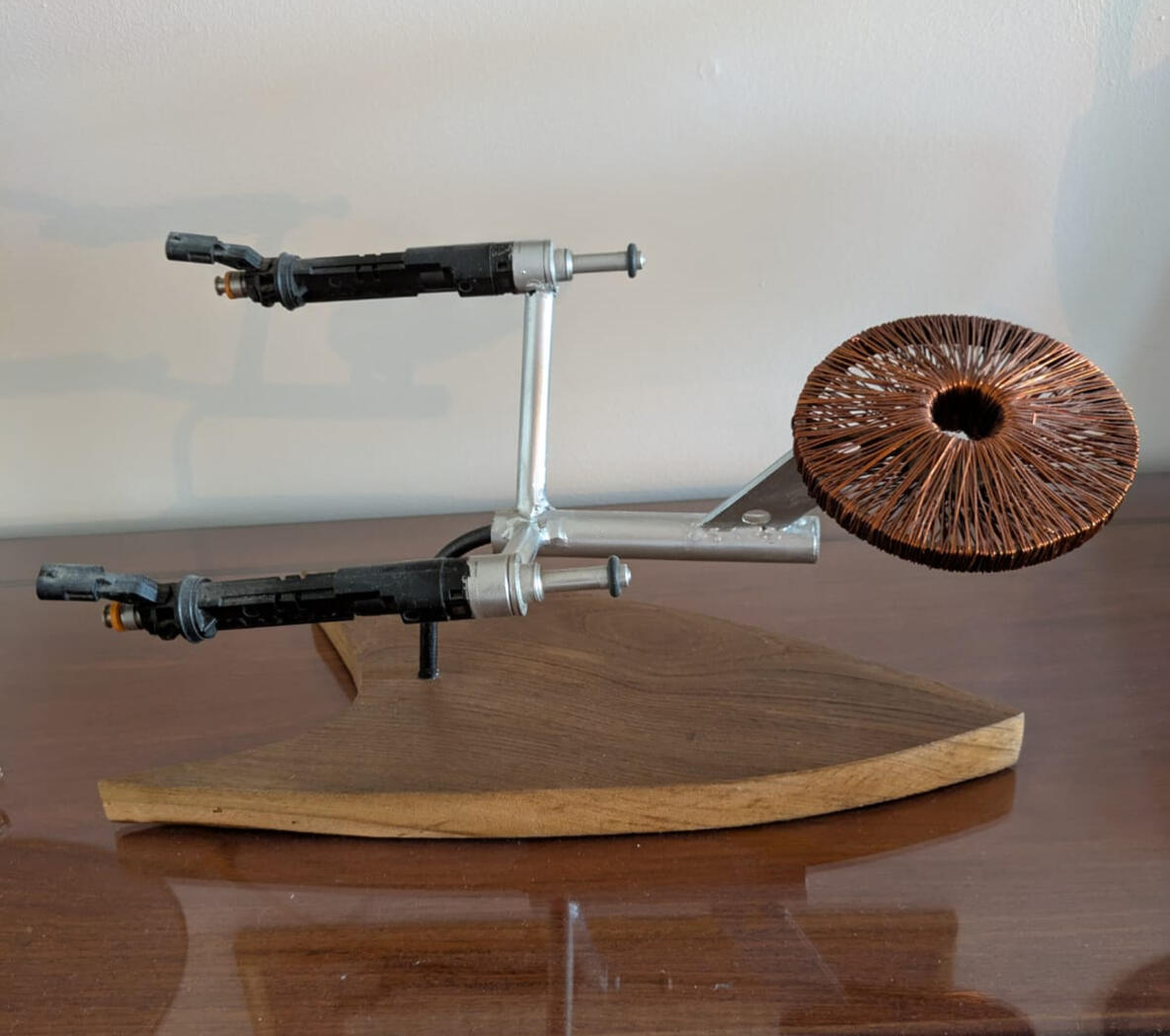 Salvaged automotive fuel injectors, electric motor copper wire, reclaimed steel, chestnut wood. Dimensions variable | Table sculpture